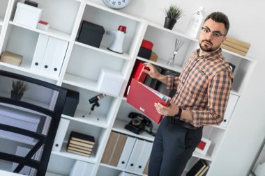 Klasörleri raf ofiste bir adam ortaya çıkarır.