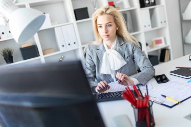 Genç kız ofiste bilgisayar ve belgeler ile çalışma.