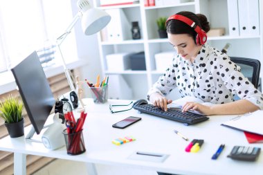 Kulaklık Office masada oturan ve klavyede yazarak güzel genç kız.