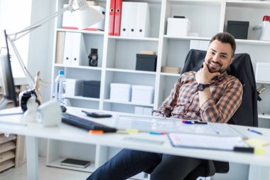 Bir adam ofiste bir masada oturuyor.