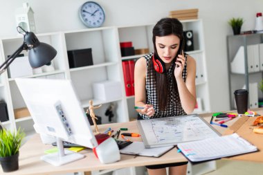 Genç bir kız bir masanın ayakta, yeşil bir işareti onun elinde tutan ve Evet. Kızlar kulaklık boynuna asmak.