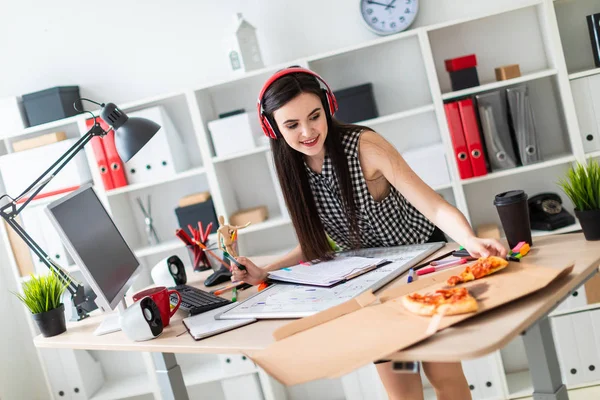 Genç bir kız tablonun duruyor, bir yeşil işareti onun elinde tutan ve bir parça pizza alır. Önce kız masanın üzerinde manyetik bir pansiyondur. Kulaklıklar giyen kız kafasına.