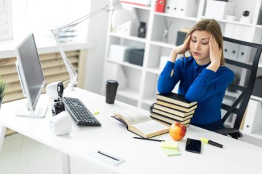 Genç bir kız bir bilgisayar masada oturur ve onun ellerini başının tutar. Önce kız açık bir kitap yatıyor.
