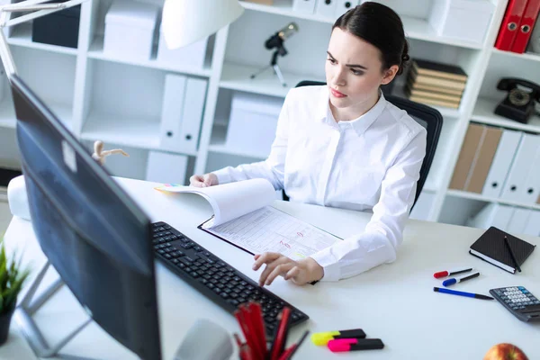 Jong meisje in het kantoor werken met documenten op de computer. — Stockfoto