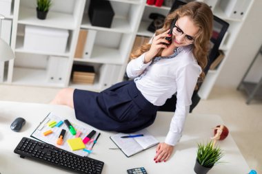 Güzel bir genç kız ofiste masaya oturdu ve telefonda konuşuyordum. Hoşlandığın kızın önünde belgeleri vardır.