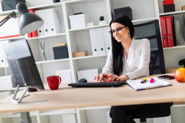 Genç bir kız masada oturan ve metin klavyede yazarak.