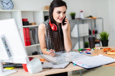 Genç bir kız bir masanın ayakta, yeşil bir işareti onun elinde tutan ve Evet. Kızlar kulaklık boynuna asmak.