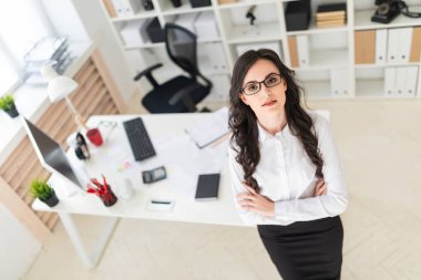 Güzel bir genç kız Ofis Masası göğsüne sıktı elleri duruyor..