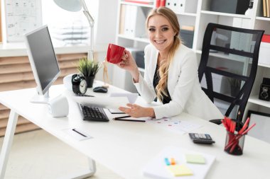Güzel genç kız sarışın saç beyaz ceket ve siyah bluz ile ofiste çalışıyor. alan derinliği ile fotoğraf