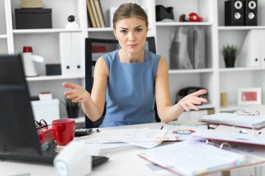Genç bir kız onun ofisinde bir masada oturur ve taraf için kollarını açtı.