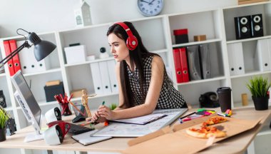 Genç bir kız bir masanın ayakta, yeşil kalem tutan ve ekrana bakarak. Önce kız masanın üzerinde manyetik bir pansiyondur. Kulaklıklar giyen kız kafasına.