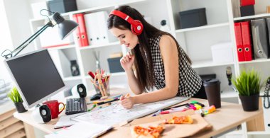 Genç bir kız bir tablo duruyor, turuncu bir işaret onun elinde tutan ve manyetik tahtaya benziyor. Kulaklıklar giyen kız kafasına.