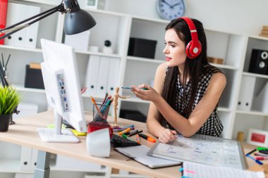 Genç bir kız bir tablo duruyor, bir yeşil işareti onun elinde tutan ve bir bilgisayar ve bir manyetik kurulu ile çalışır. Kulaklıklar giyen kız kafasına.