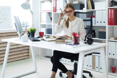 Genç bir kız ofiste bir masada oturur ve bir kalem elinde tutar. Önce kız açık bir kitap yatıyor.