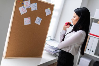 Genç bir kız bir işaretleyici elinde tutan ve kurulu çıkartmaları ile yakındaki standları.