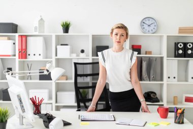 Genç sarışın kız ofiste bir tabloda yakınındaki standları.