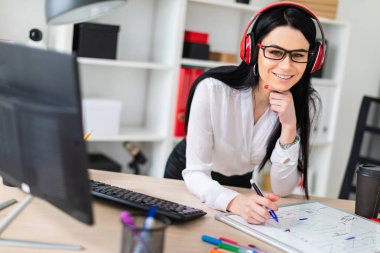 Genç bir kız kulaklık tablo anlamına gelir ve bir işaretleyici manyetik bir tahtaya çizer.