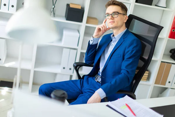 Ein junger Mann sitzt an einem Tisch im Büro. — Stockfoto