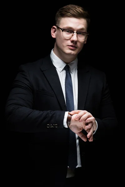 Portrait of confident handsome ambitious happy elegant responsible businessman with hand on hand on black background — Stock Photo, Image