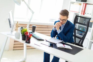 Genç adam ofiste masada oturan ve belgeleriyle çalışma.