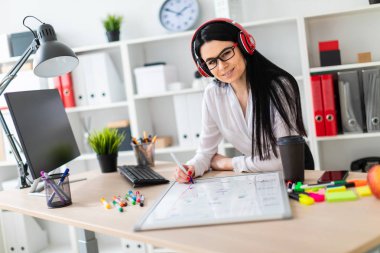 Genç bir kız kulaklık tablo anlamına gelir ve bir işaretleyici manyetik bir tahtaya çizer.