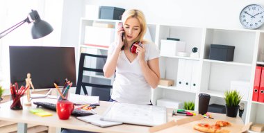 Genç bir kız bir masanın ayakta, telefonda konuşurken ve bir işaretleyici elinde tutan. Masaya manyetik bir pansiyondur. Kızlar kulaklık boynuna asmak.