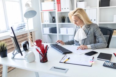 Genç kız ofiste bilgisayar ve belgeler ile çalışma.