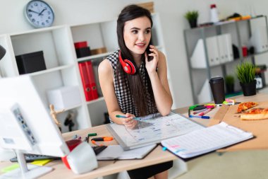 Genç bir kız bir masanın ayakta, yeşil bir işareti onun elinde tutan ve Evet. Kızlar kulaklık boynuna asmak.