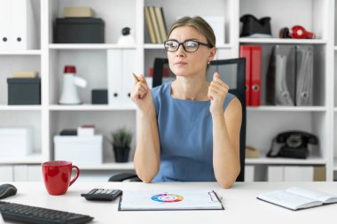 Genç bir kız ofiste bir masada oturur ve bir belgeyi içeren bir grafik görünüyor.