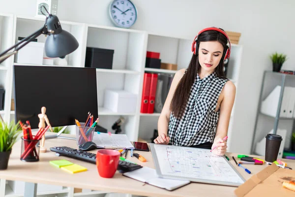 Genç bir kız bir tablo duruyor ve bir işaretleyici onun sol elinde tutar. Bir manyetik tahta tablodur.