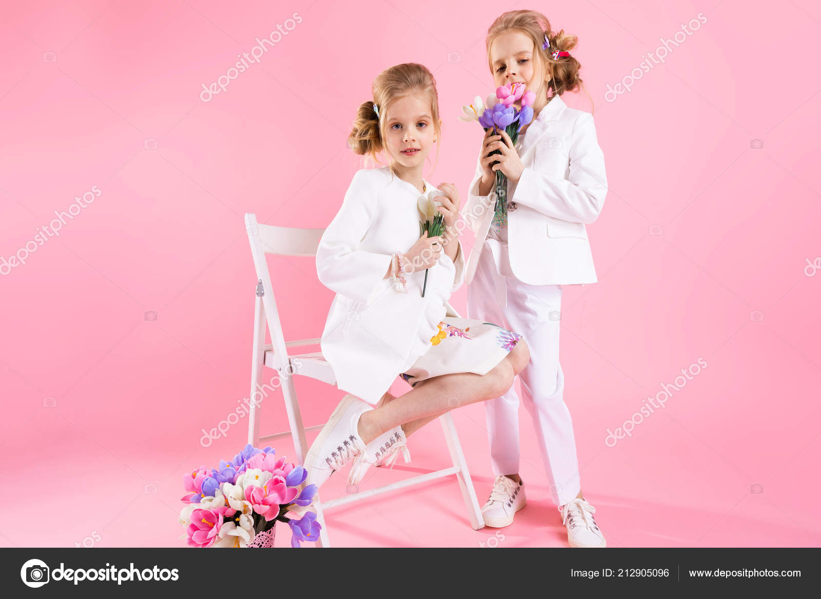 Twins Girls In Light Clothes With Bouquets Of Flowers Posing