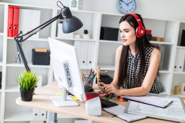 Genç bir kız bir masanın ayakta, yeşil kalem tutan ve ekrana bakarak. Önce kız masanın üzerinde manyetik bir pansiyondur. Kulaklıklar giyen kız kafasına.