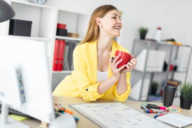 Genç bir kız bir tablo duruyor ve kırmızı bir fincan ve bir işaretleyici onun elinde tutar. Önce kız masanın üzerinde bir manyetik tahta