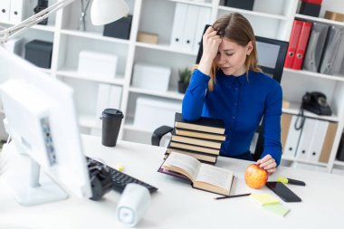 Genç bir kız bir bilgisayar masada oturur ve kafasına elini tutar. Önce açık bir kitap ve bir elma kız yatıyor.
