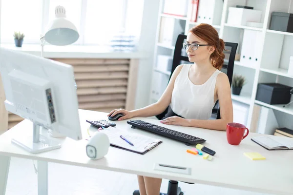 Vacker ung flicka i kontoret arbetar vid datorn. — Stockfoto