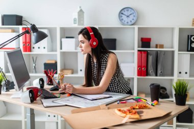 Genç bir kız bir masanın ayakta, yeşil kalem tutan ve ekrana bakarak. Önce kız masanın üzerinde manyetik bir pansiyondur. Kulaklıklar giyen kız kafasına.