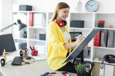 Genç bir kız bir masaya oturur ve bir işaretleyici ve manyetik bir tahta onun elinde tutar. Kızlar kulaklık boynuna asmak.