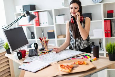 Genç bir kız bir masanın ayakta, yeşil bir işareti onun elinde tutan ve Evet. Kızlar kulaklık boynuna asmak.