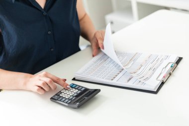 Kadınların elleri hesap makinesine güvenir ve formu doldurur.