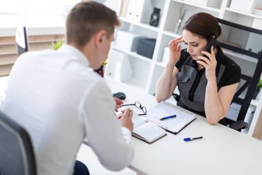 Yatırımcı Smartphone'da meslektaşım ofiste iş toplantısında konuşuyor 