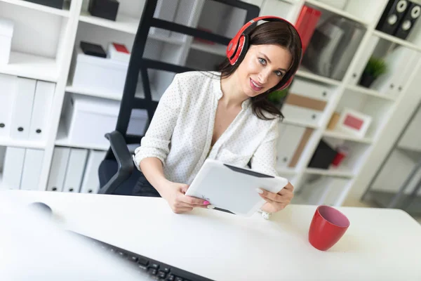 young businesswoman in the office with headphones and tablet pc