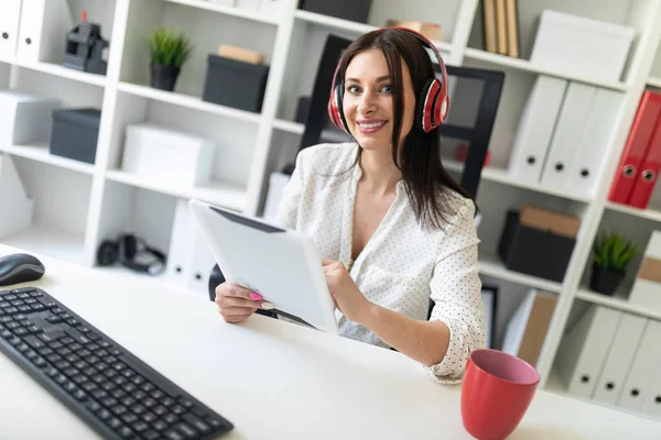 young businesswoman in the office with headphones and tablet pc