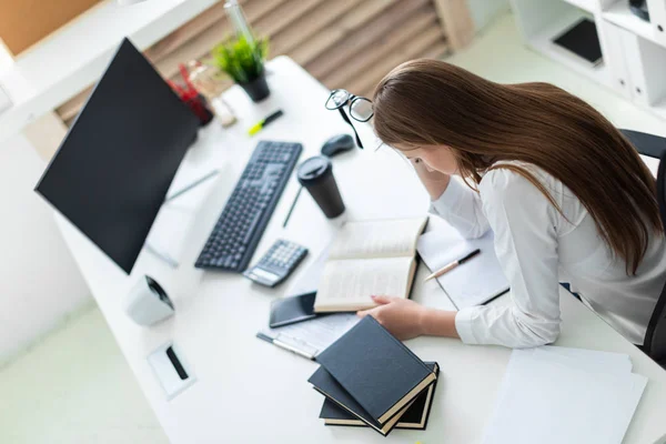 Uma jovem sentou-se na mesa e trabalha com um computador, documentos e calculadora — Fotografia de Stock