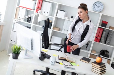 Güzel bir genç kız bir grup başında beyaz gömlek ve siyah yelek ile parlak bir ofiste çalışıyor. alan derinliği ile fotoğraf