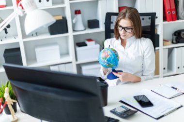 Parlak bir ofiste çalışan sevimli genç kız. Beyaz bluz ve siyah pantolonlu genç kız. Uzun kahverengi saçları var. Gözlük ve güzel makyaj ile kız. 