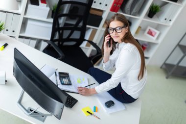Masada oturan ve ofiste çalışan genç kız