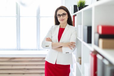 İş takım elbiseli güzel genç kız ofiste duruyor