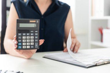 Kadınların elleri hesap makinesine güvenir ve formu doldurur.
