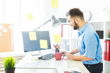 bir tablo ve works belgeleri ile ofiste genç adam.