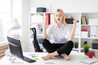 oturma ve ofiste bir tablo üzerinde meditasyon genç iş kadını.